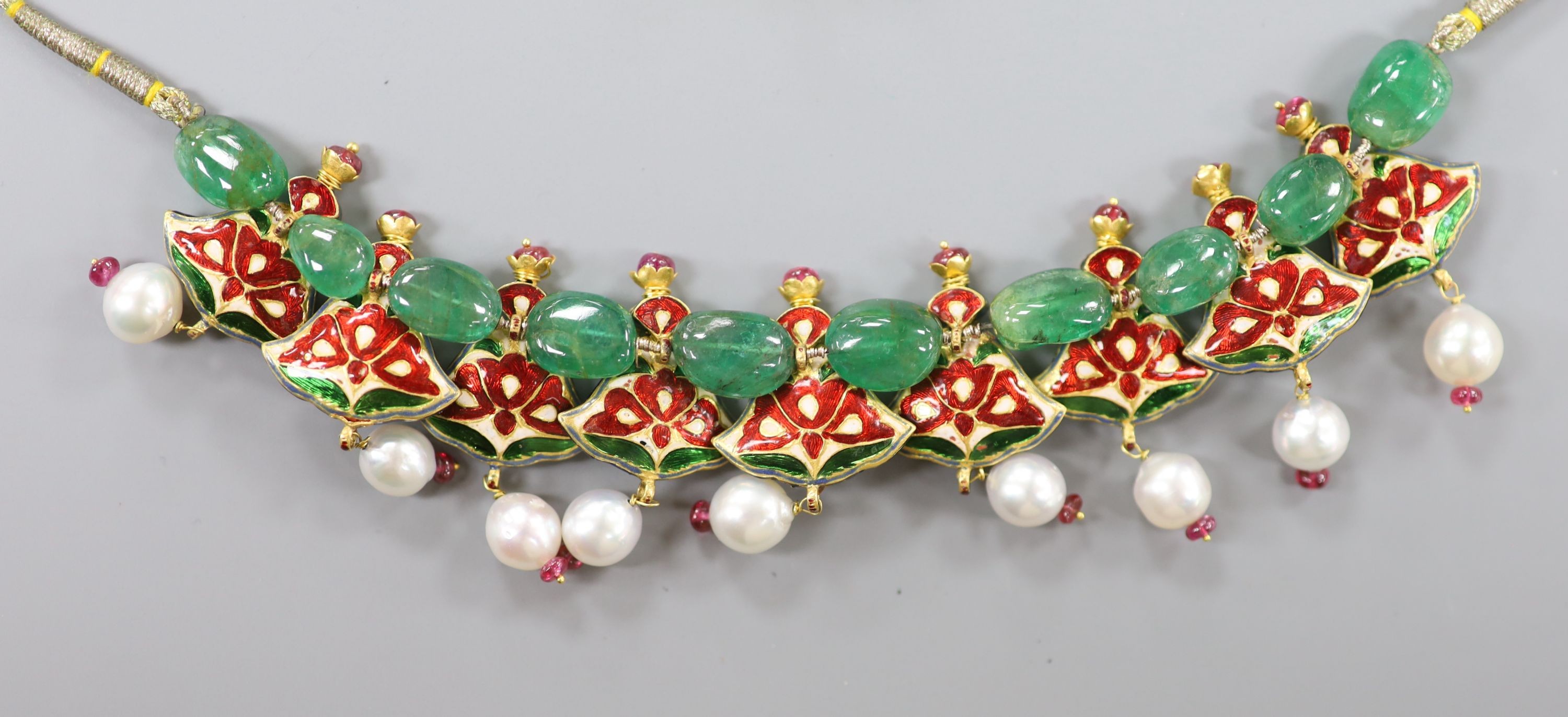 An Indian? emerald, garnet, ruby, enamel and cultured pearl set drop necklace, with fabric chain, overall approx. 68cm.